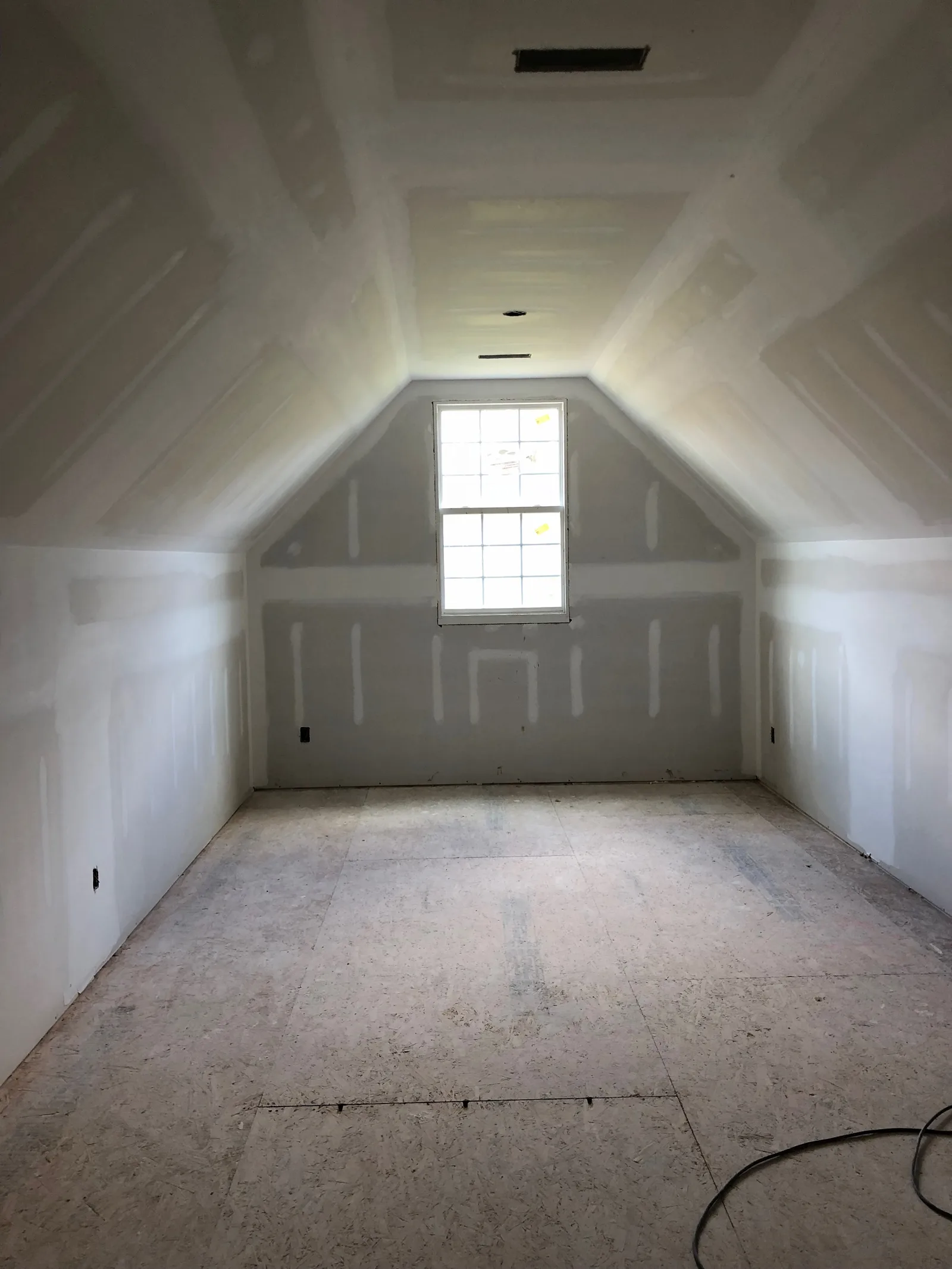 Newly installed and taped drywall in an attic room