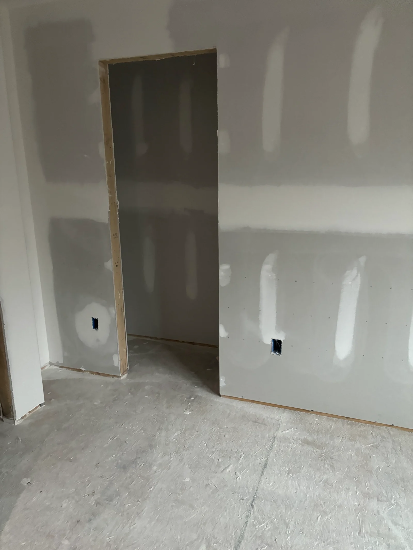 New drywall with taped joints around an interior doorway