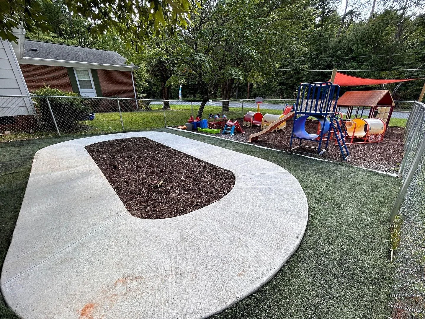 Curved concrete walkway around a garden bed