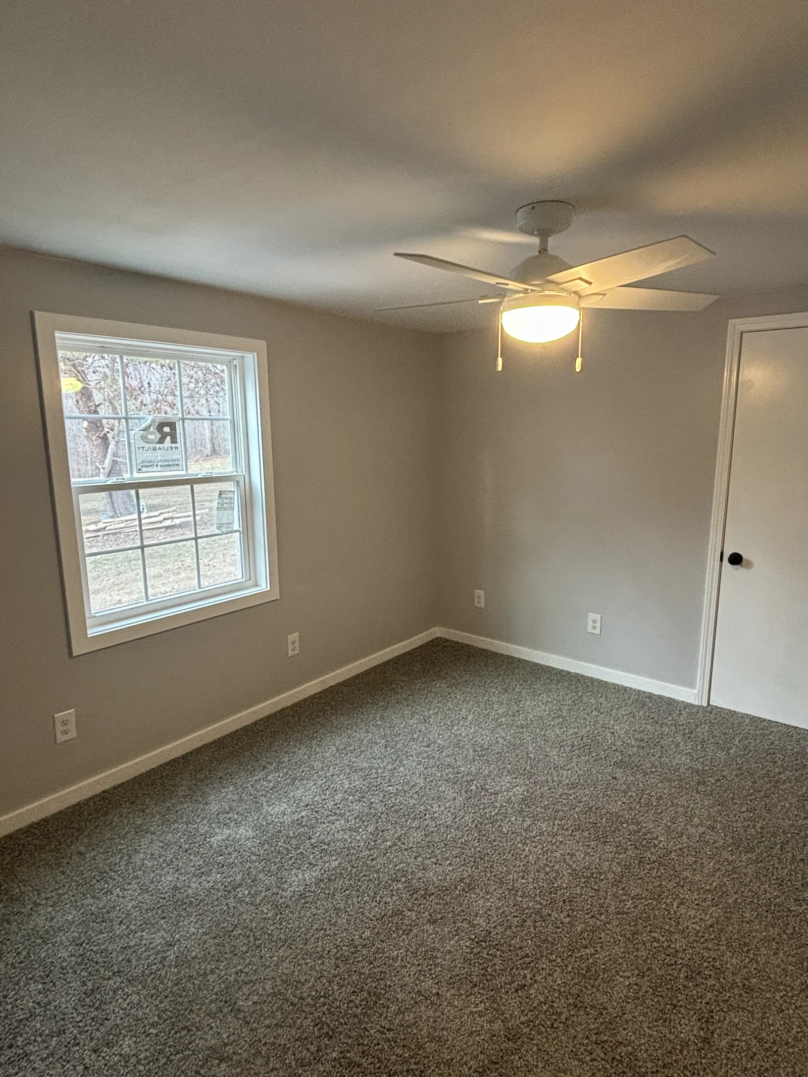 Finished bedroom with neutral painted walls, white trim and carpet