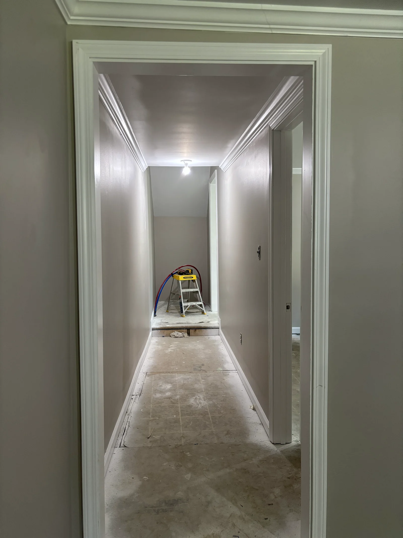 Hallway with grey painted walls and white trim during renovation