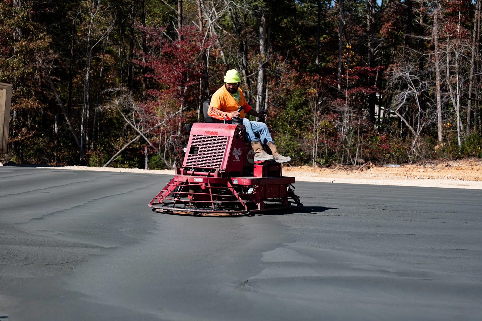 Crew member machine-finishing a concrete slab
