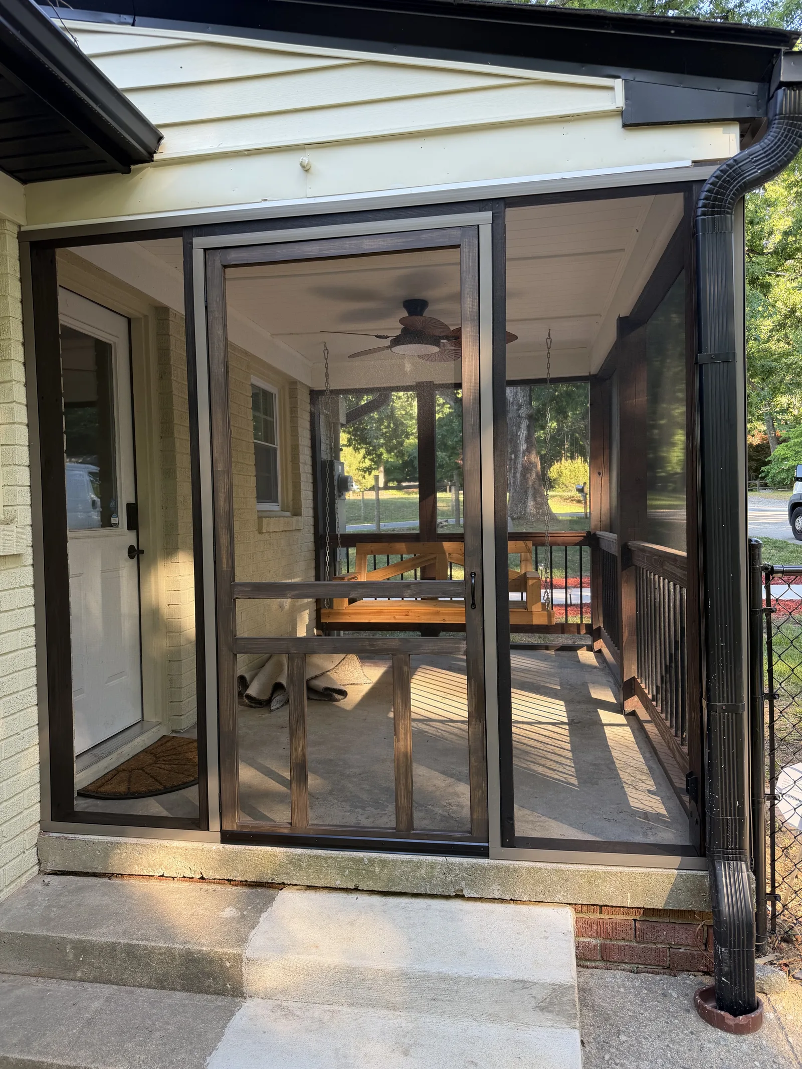 Completed screened patio with dark framing and screen door