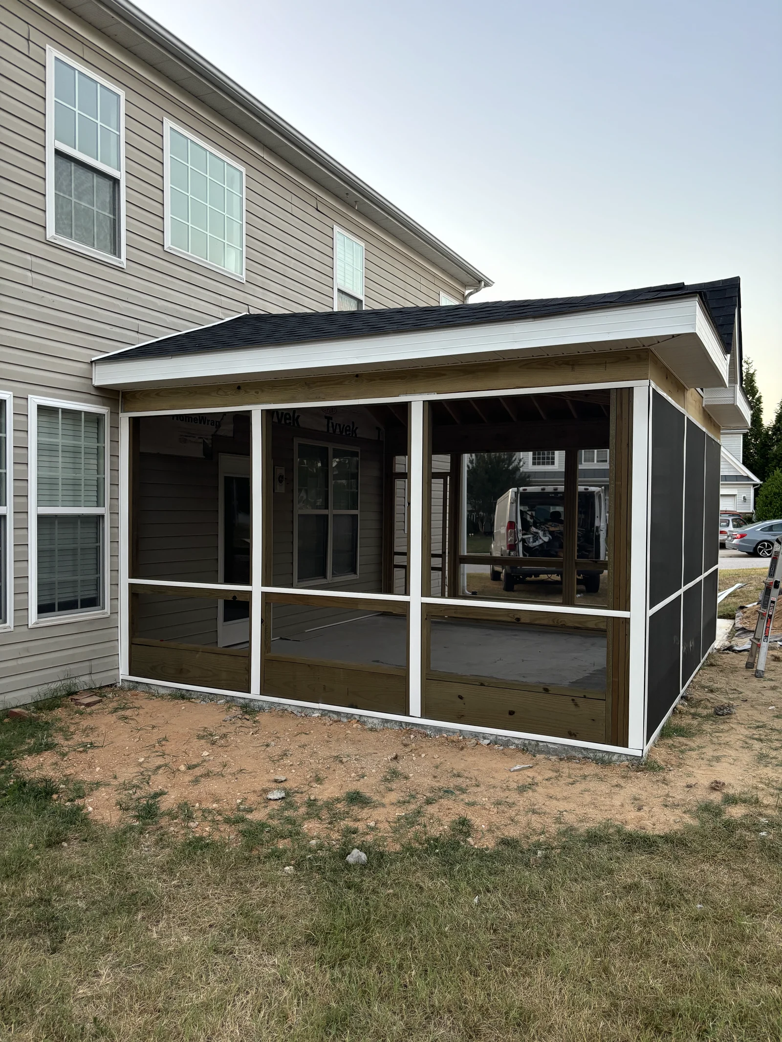 Screened patio attached to a two-story home, viewed from the side