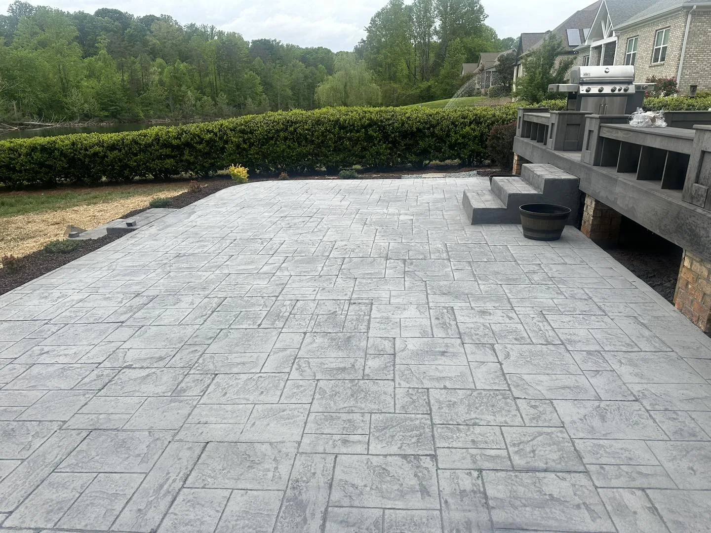 Patterned concrete terrace beside a raised deck