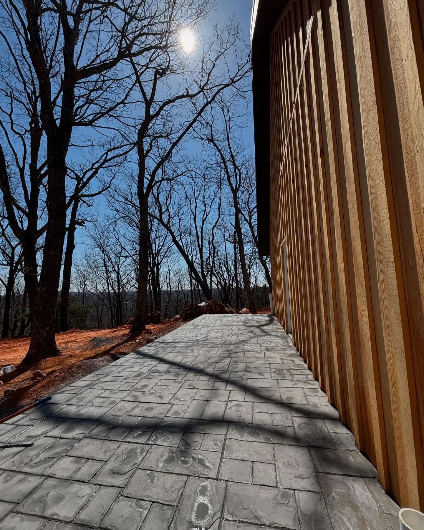 Patterned concrete walkway beside a timber building