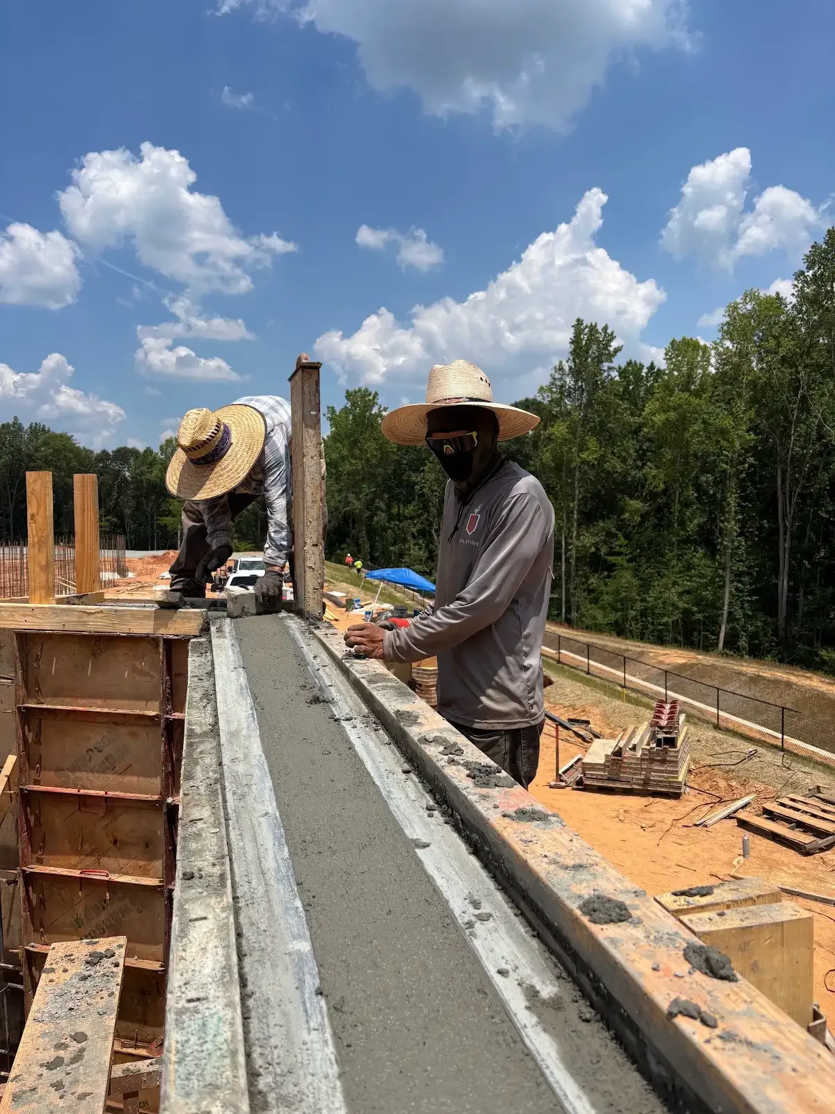 Crew finishing the top of a formed concrete wall