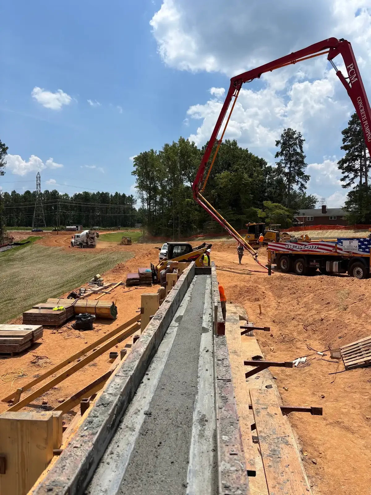 Concrete pump reaching across a formed wall project