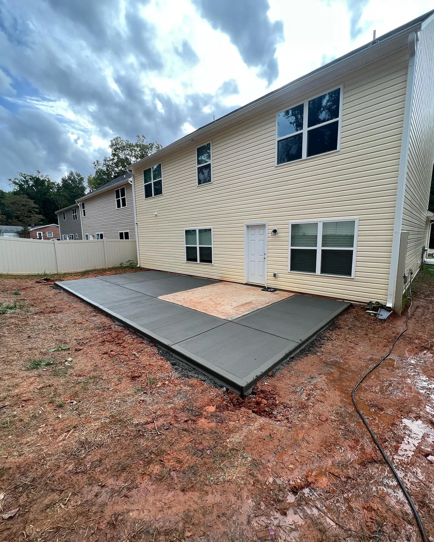 Concrete patio wrapping around the rear of a home